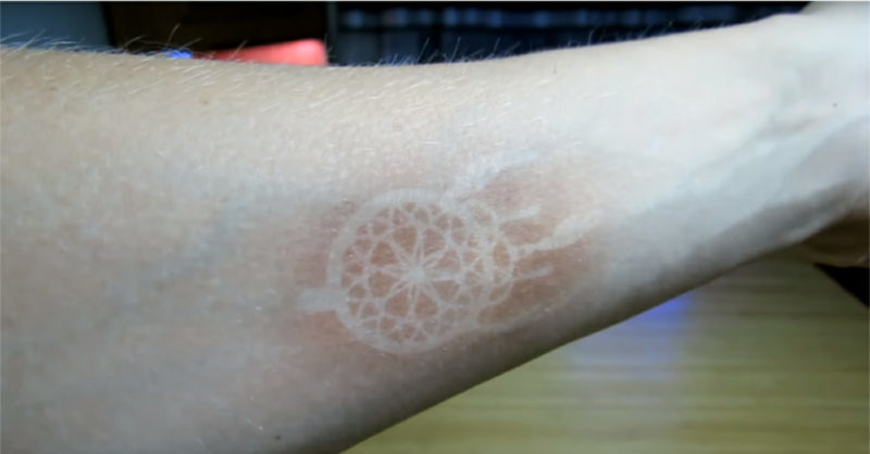 The result of the experiment. Tanning after dozens of five-minute exposure sessions with an ordinary UV lamp at a wavelength of 365 nm through a patterned stencil.