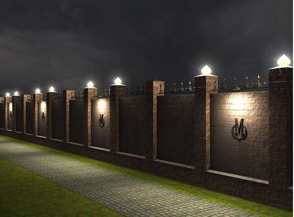 Overhead lighting on a solid fence.