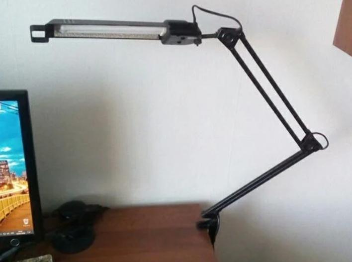 Luminaires that mount on the edge of a desk top